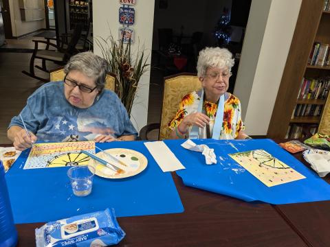 2 friends paint with acrylics on canvas at Seton Kenton Apartments.